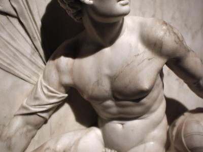 A close-up photograph of a white marble sculpture depicting a reclining male figure with curly hair, identified by the filename as "Marte in Riposo" (Resting Mars) by Antonio Lombardo, located within the Galleria Estense.