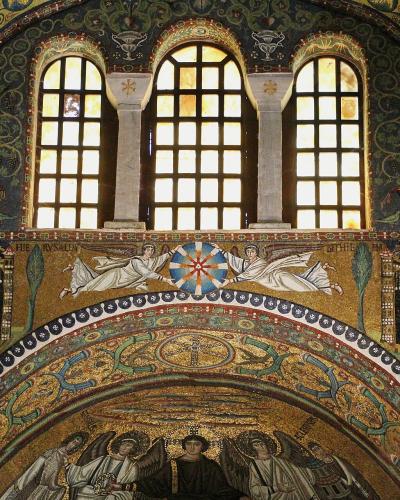 The image shows the interior apse and arch of a Byzantine-style church, featuring elaborate gold-ground mosaics with figures of angels, a central Christogram, and architectural details like arched windows and decorative borders.