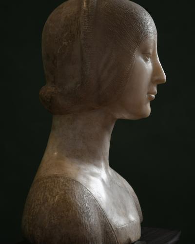 A close-up photograph of a deteriorated fresco depicting two women in profile wearing period headwear and jewelry, with visible cracking and pigment loss on the wall surface.