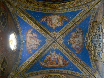 The image shows an ornate, vaulted ceiling with blue starry frescoes, painted figures on clouds, gilded architectural ribs, a rose window, and part of a pipe organ.