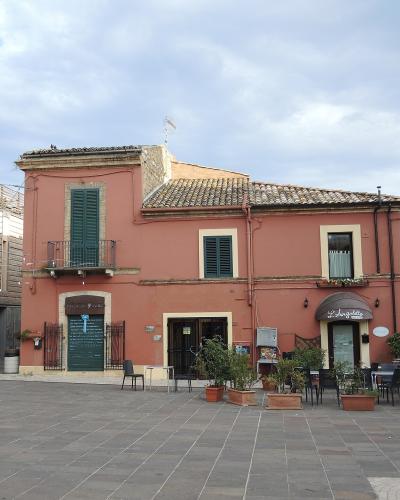 The image shows a paved public square in front of a salmon-pink building with green shutters and an awning labeled "La Langhetto," identified by the filename as Piazza Ducale in Giulianova, Italy.