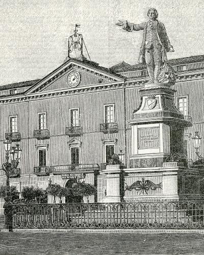 A black-and-white engraving showing a large public square with a prominent statue of Luigi Vanvitelli on a pedestal in the foreground and a grand neoclassical building behind it, identified by signage as "BANCA NAZIONALE DEL LAVORO" (National Bank