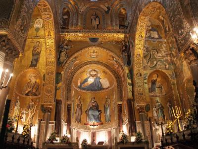 The image shows the interior of a highly ornate Byzantine-style chapel with extensive gold mosaics, including a central mosaic of Christ Pantocrator in the apse, flanked by saints and angels, with Latin inscriptions and distinctive spiral columns.
