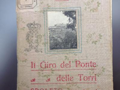 A vintage book cover titled "Il Giro del Ponte delle Torri" by Domenico Pacieri, featuring a small inset photograph of a stone bridge structure amidst foliage, with library stamping and the location "SPOLETO" printed on the cover.