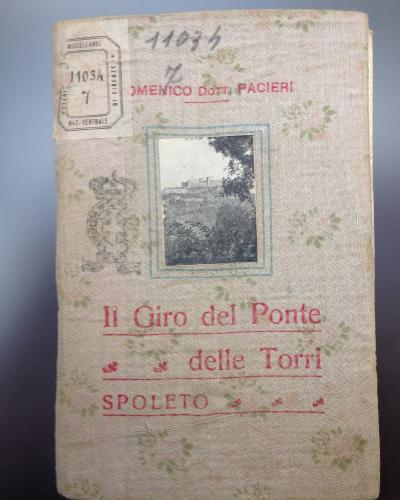 A vintage book cover titled "Il Giro del Ponte delle Torri" by Domenico Pacieri, featuring a small inset photograph of a stone bridge structure amidst foliage, with library stamping and the location "SPOLETO" printed on the cover.