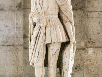 A marble statue of a standing male figure (San Liberale) displayed indoors against a stone wall, with an informational placard identifying it as "San Liberale" from the "Musei Civici di Treviso".