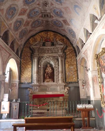 The image shows the interior of a church with a decorated ceiling, an ornate altar featuring a statue of the Virgin Mary under the inscription "ALTARE PRIVILEGIATO", and a large painting on the right wall.