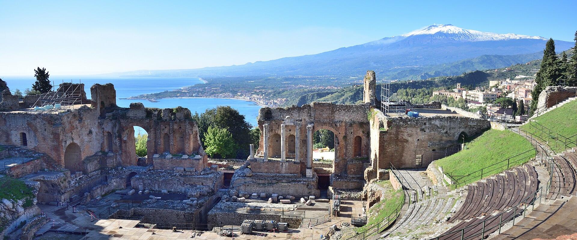 The ancient Greek theatre of Taormina with Mount Etna and the Sicilian coast beyond