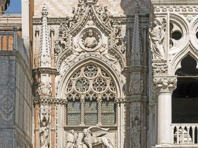 The image shows the ornate Gothic facade of the Porta della Carta, the main entrance to the Doge's Palace in Venice, featuring a large winged lion statue and a poster for a Henri Rousseau exhibition.