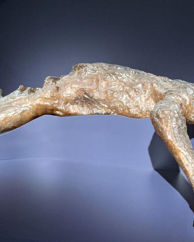 A plaster cast of a human victim from the eruption of Mount Vesuvius, displayed on a modern museum pedestal against a dark background.