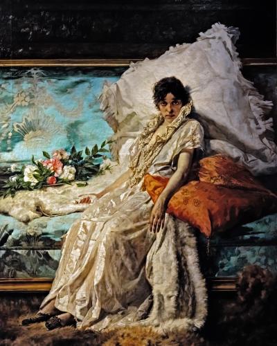 A painting of a woman in a white dress reclining on a chaise lounge with pillows and flowers, displayed within a museum setting.