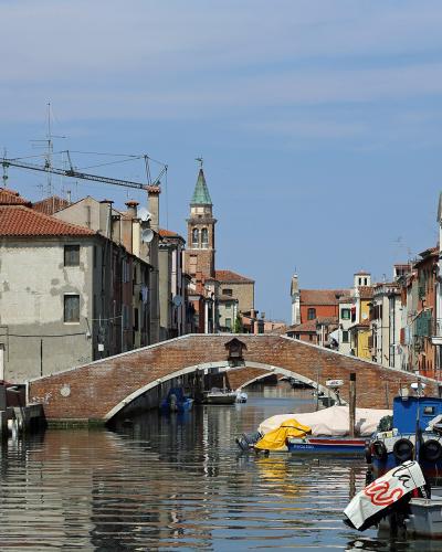 Boats and a stone bridge on the Canal Vena in Chioggia, beside the fish market